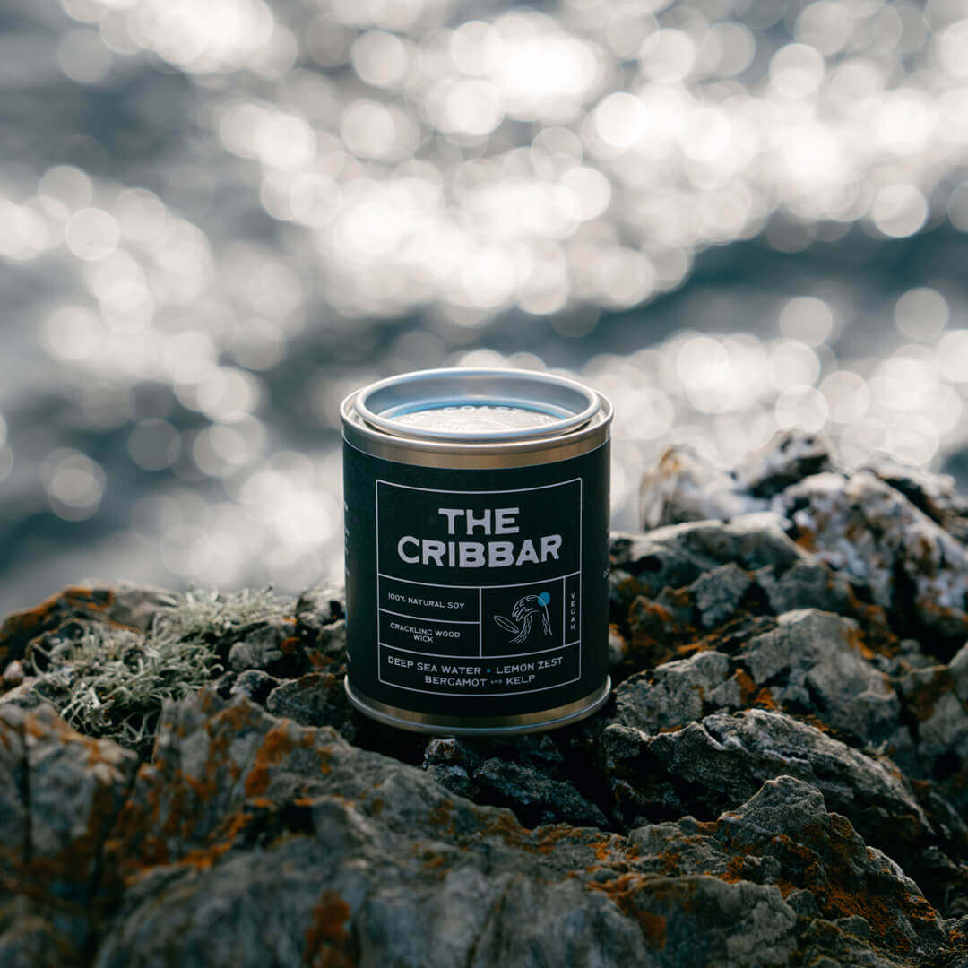 he Cribbar ocean-scented soy candle by Kernowfornia Soul, handmade in Cornwall, clean burning and eco friendly in a black tin on Newquay’s rugged coast with deep blue sea—ideal surfer-inspired gift.
