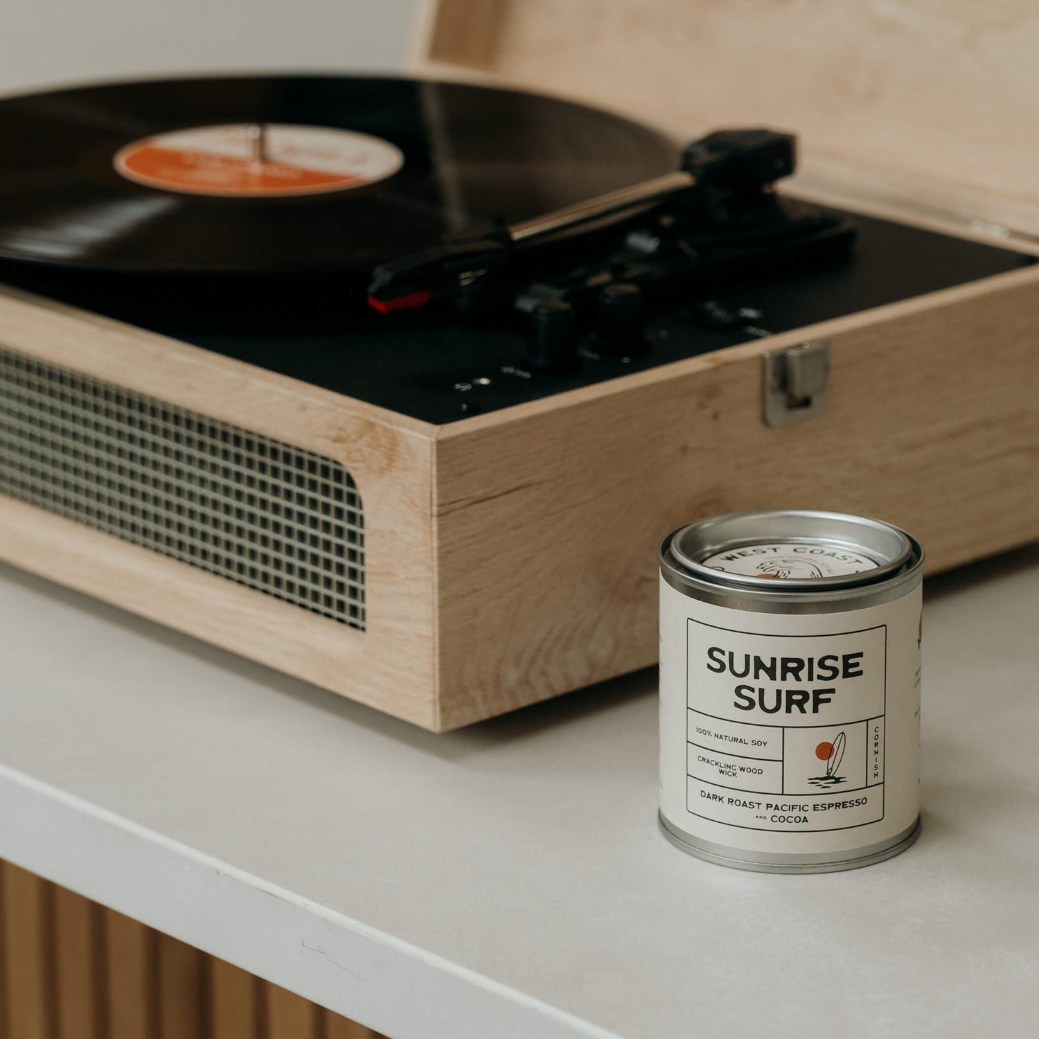 Sunrise Surf espresso soy candle beside a retro record player in a Californian-style kitchen with natural wood tones and laidback surfer aesthetic