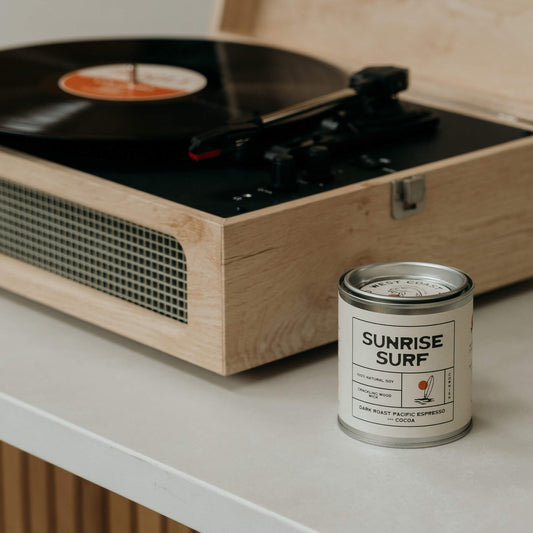 Sunrise Surf espresso soy candle beside a retro record player in a Californian-style kitchen with natural wood tones and laidback surfer aesthetic